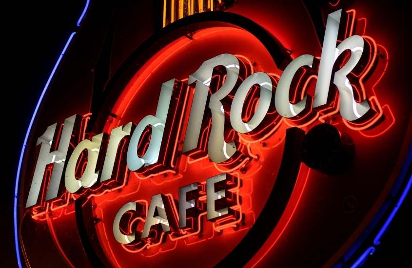 durante a noite, placa vermelha iluminada, onde há escrito 'hard rock cafe'