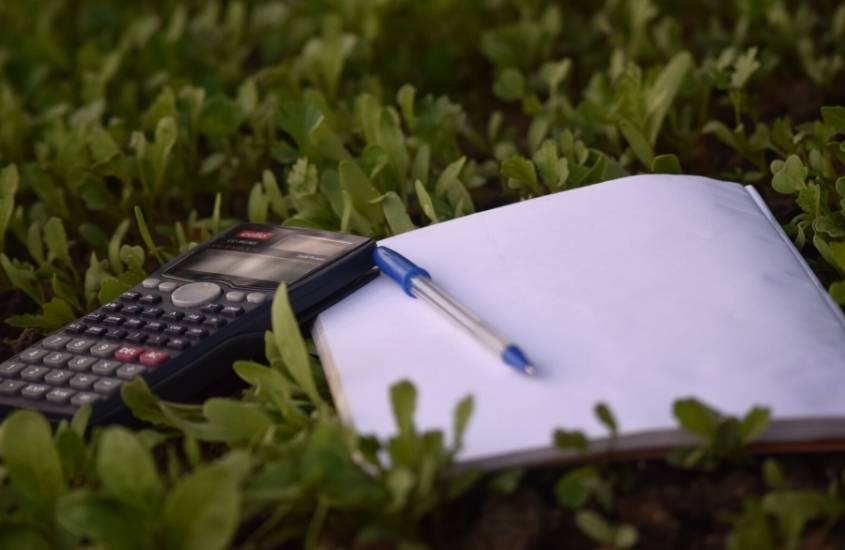 calculadora, caneta e papel em cima de gramado, para celular custo de roteiro genebra