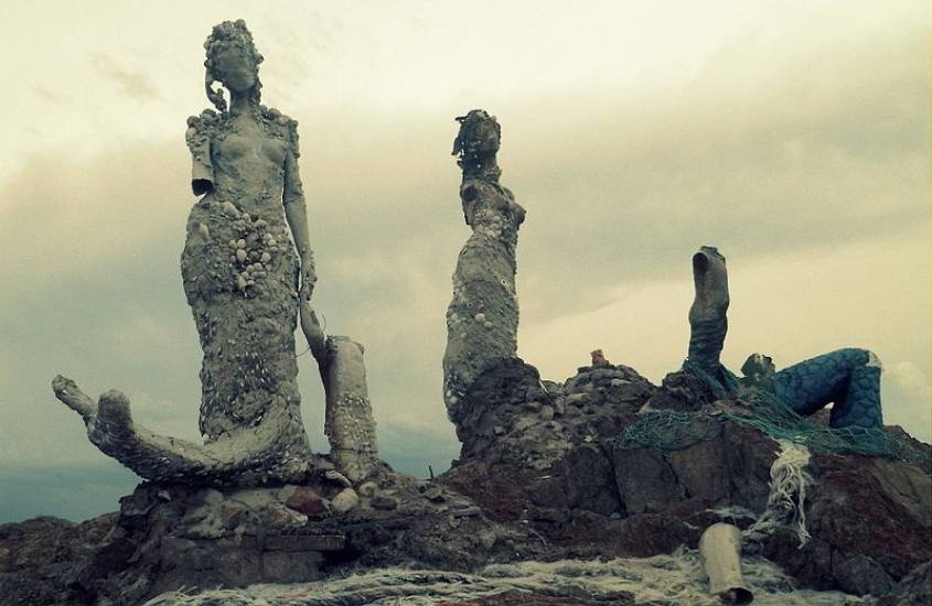 durante dia nublado, esculturas de sereias em cima de pedras