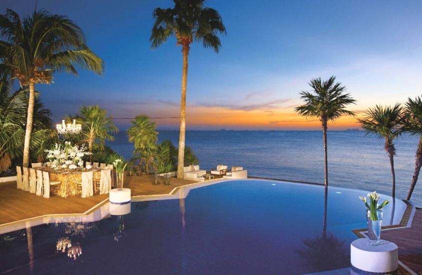 durante o entardecer, piscina de borda infinita com vista para o mar em terraço de um dos melhores hoteis em cancun