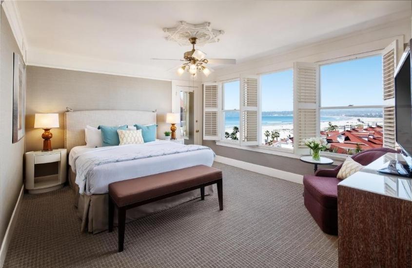 durante o dia, abajur, cama de casal e sofá em suíte de um hotel em san diego com vista para a praia