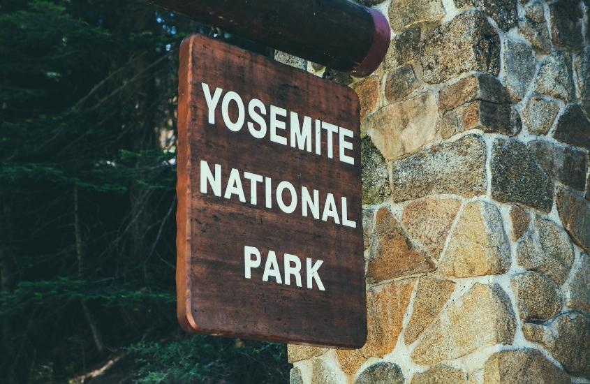 placa de madeira onde há escrito em branco: yosemite national park