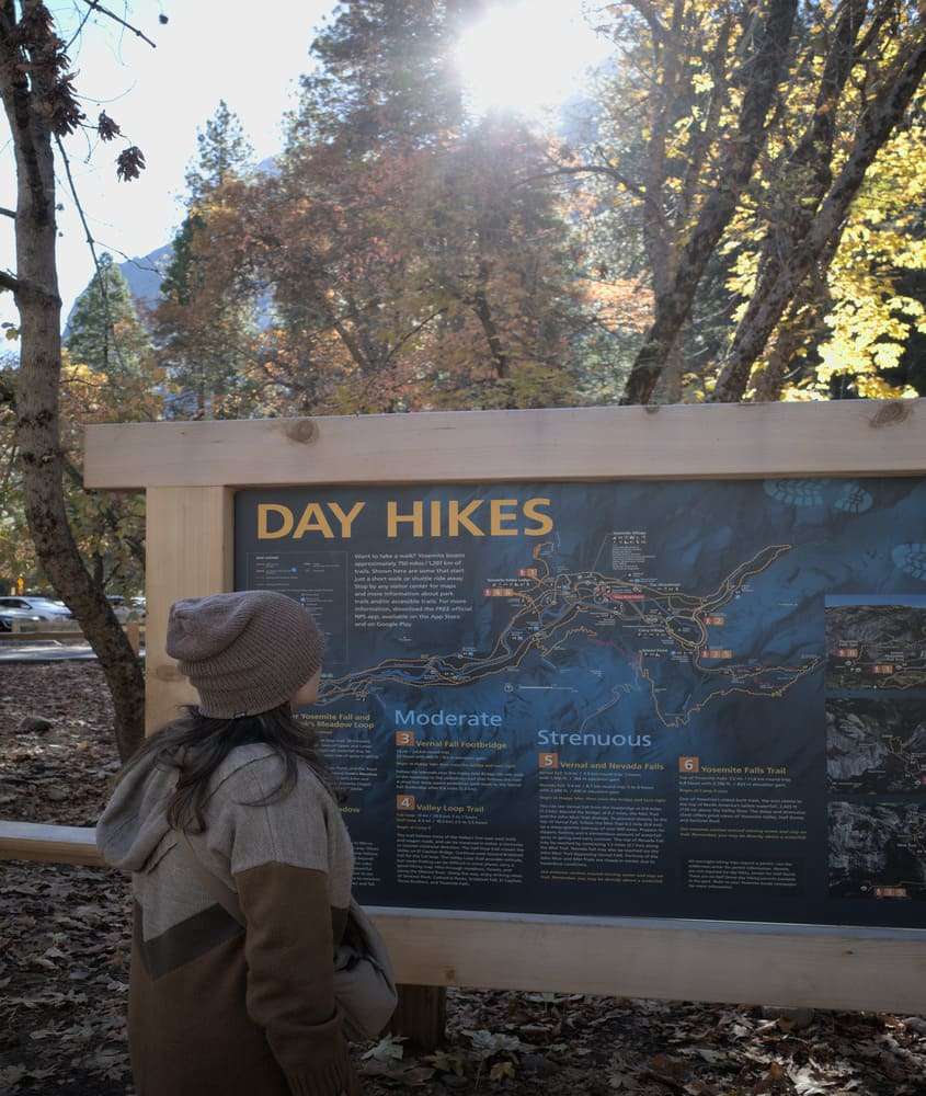 durante o dia, Bárbara Rocha observa placa no Parque Yosemite