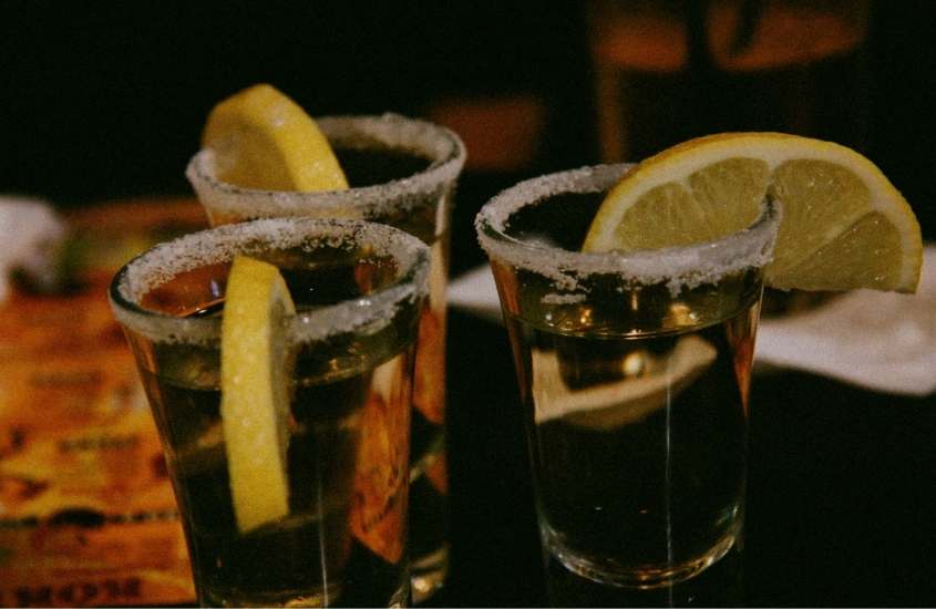 três copos de tequila em cima de mesa