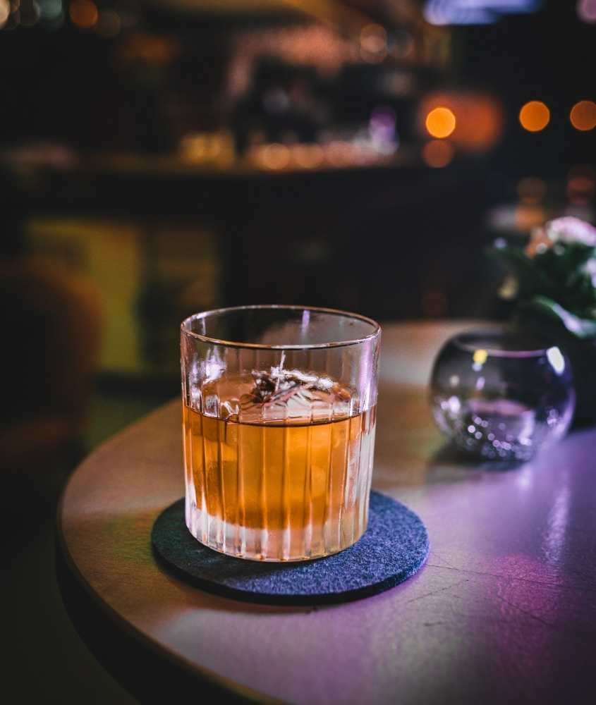copo com whisky, em cima de mesa de madeira em bar, atração para lista de o que fazer em houston a noite
