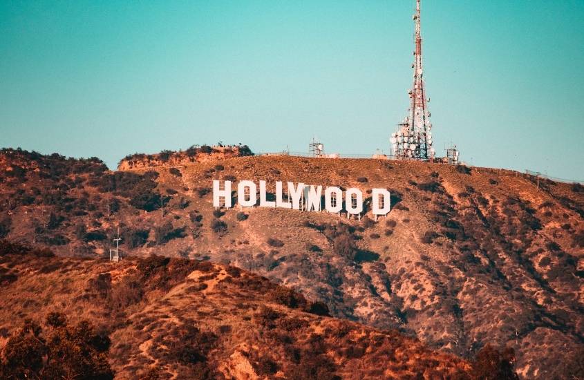 durante o dia, vista aérea de letreiro branco escrito 'hollywood'' em topo de montanha
