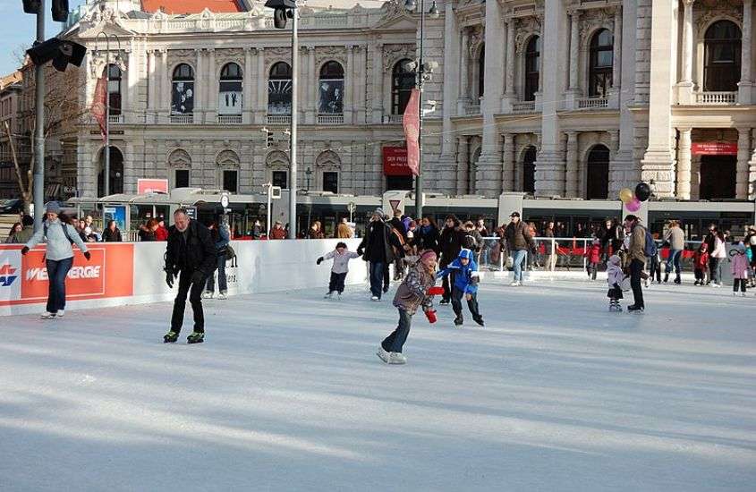 durante o dia, pessoas patinando em pista de gelo, atração para quem busca o que fazer em viena no inverno