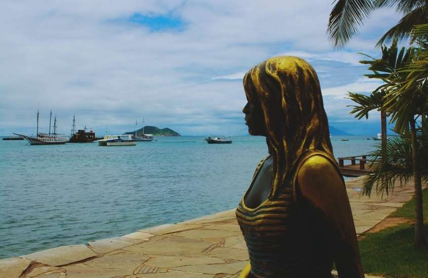 durante o dia, estatueta de atriz Brigitte Bardot, em frente a praia da armação, lugar para passar o réveillon búzios