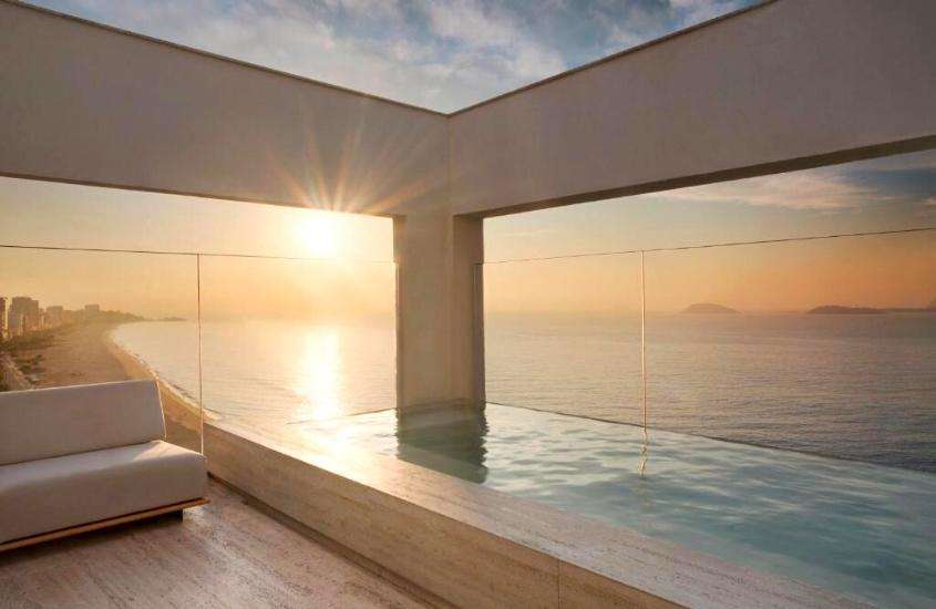 durante entardecer, piscina em varanda com vista para o mar em um dos hotéis para o réveillon no Rio de Janeiro 2023