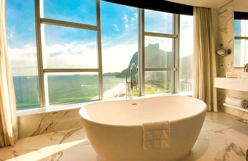 durante o dia, banheira branca em banheiro com vista para o mar