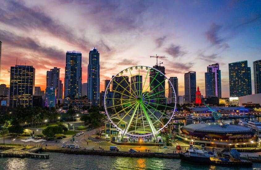 durante entardecer, vista aérea da cidade de Miami com roda-gigante e prédios à beira-mar