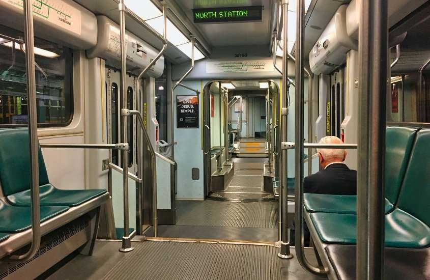 homem, de costas, sentado em metro, para fazer passeios em Boston