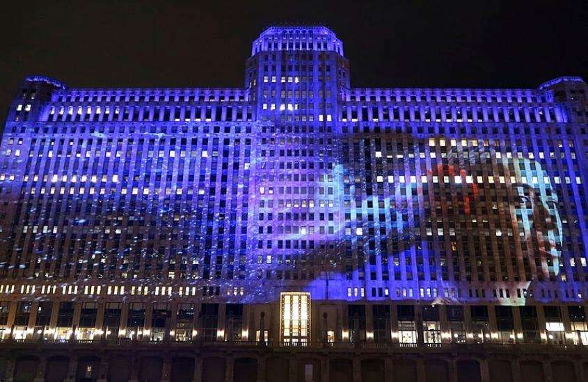 durante a noite, arte com luzes roxas projetada em grande edifício