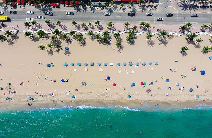 durante o dia, vista aérea de guarda-sóis e cadeiras de praia em areia de praia