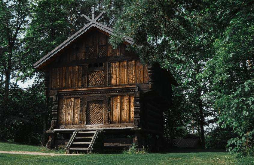 durante o dia, árvores ao redor de casa de madeira em norsk folkemuseum, um dos pontos turísticos de oslo