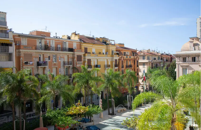 Em um dia de sol, paisagem de Beausoleil, com casas coloridas e árvores