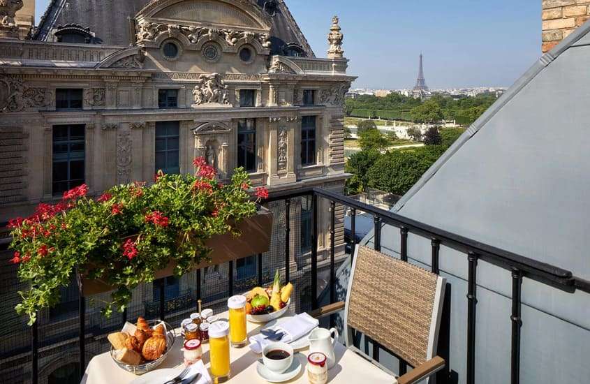 durante o dia, croissants, frutas e suco servido em mesa em varanda de hotel em Paris