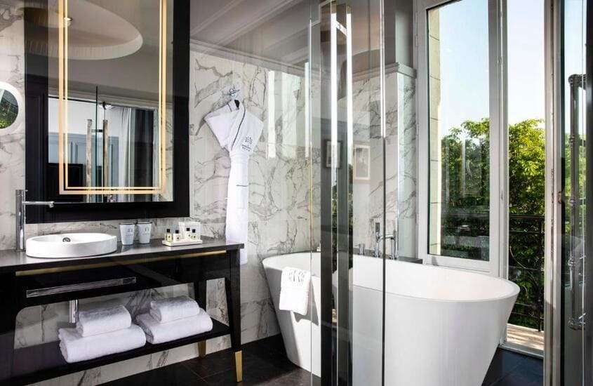 banheira em banheiro com vista da cidade em um dos melhores hotéis em Paris