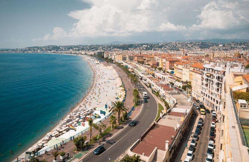 durante o dia, vista aérea de casas e prédios em frente a praia de nice, destino para viajar para França