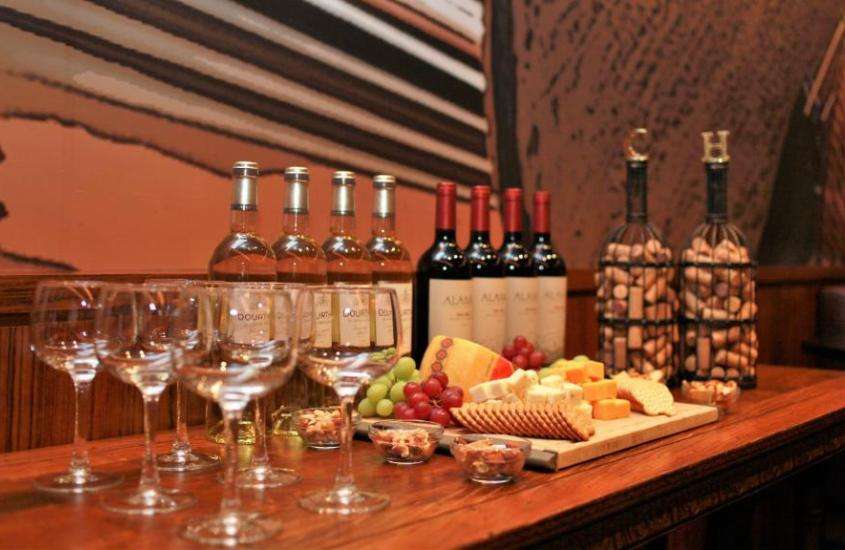 taças de vidro, garrafas de vinho e frutas em cima de mesa de madeira em salão de hotel perto do central park