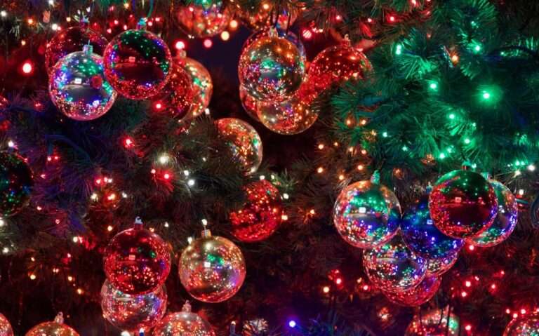bolas vermelhas e douradas iluminadas, enfeitando árvore em natal luz gramado 2022/2023