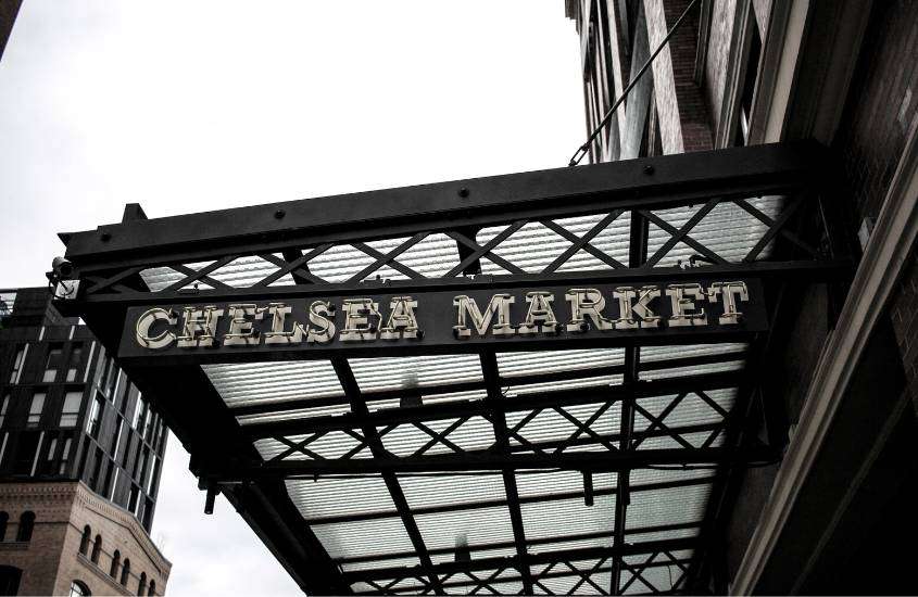 durante dia nublado, fachada preta, com letras em branco escrito 'chelsea market'