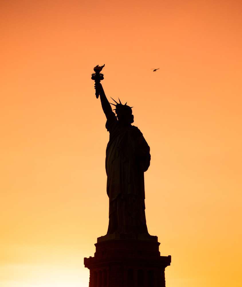 durante entardecer, silhueta de estátua da liberdade, atração para quem busca o que fazer em Nova York