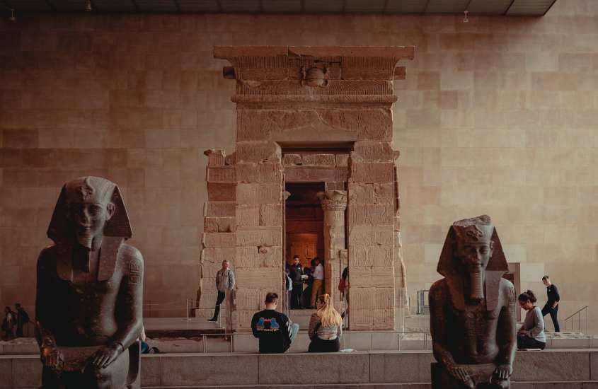 pessoas observando esculturas egípcias em um dos museus em nova york
