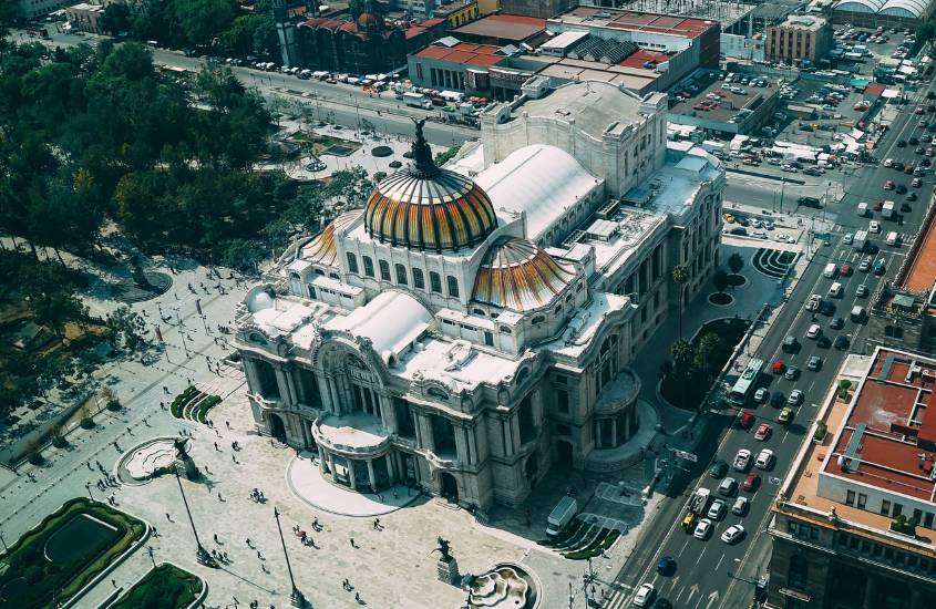 durante o dia, vista aérea de carros passando em estrada rodeada de prédios em cidade do méxico