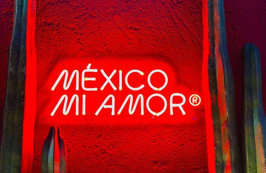 frase 'mexico mi amor' iluminada, em parede vermelha