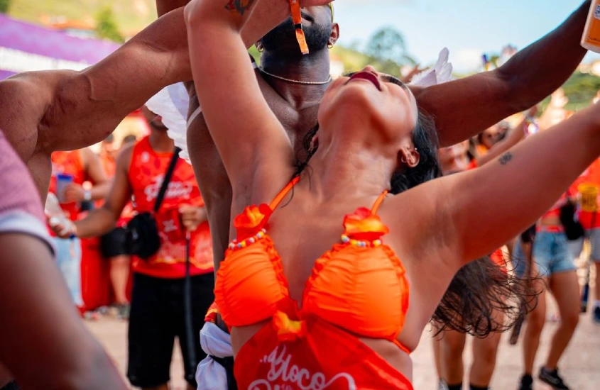 Pessoas com abadas laranjas curtindo o Bloco da Praia no Carnaval de Ouro Preto