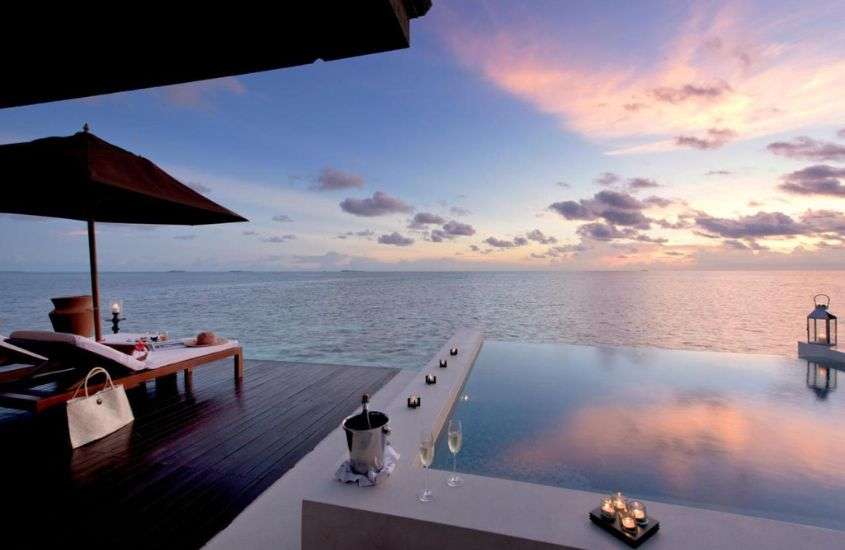 durante entardecer, espreguiçadeira, guarda-sol e piscina ao ar livre em varanda de hotel nas maldivas com vista para o mar
