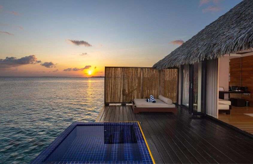 durante entardecer, piscina em varanda de bangalô em hotel nas maldivas com vista para o mar