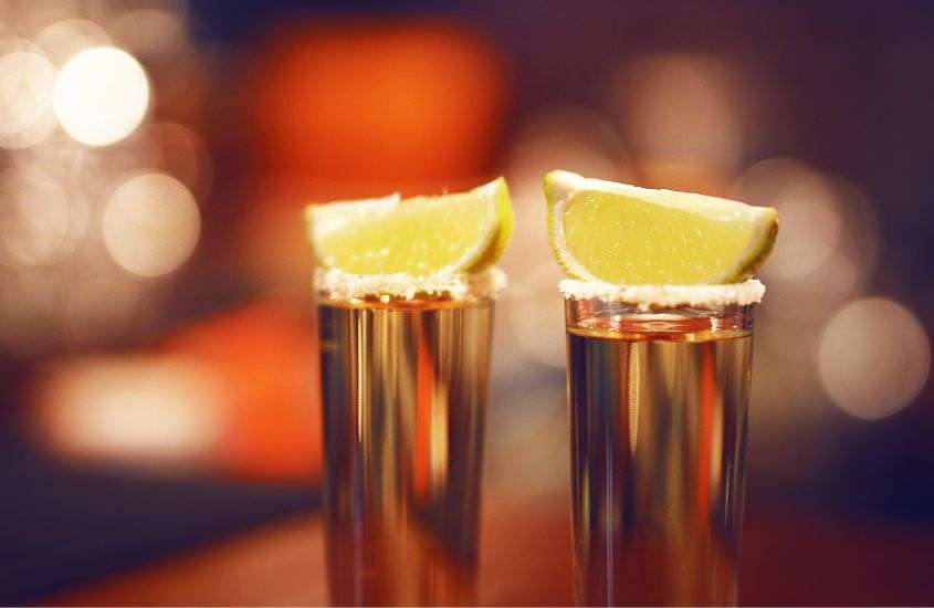 pedaços de limão em cima de dois copos de shot com tequila, bebida servida no carnaval em ouro preto