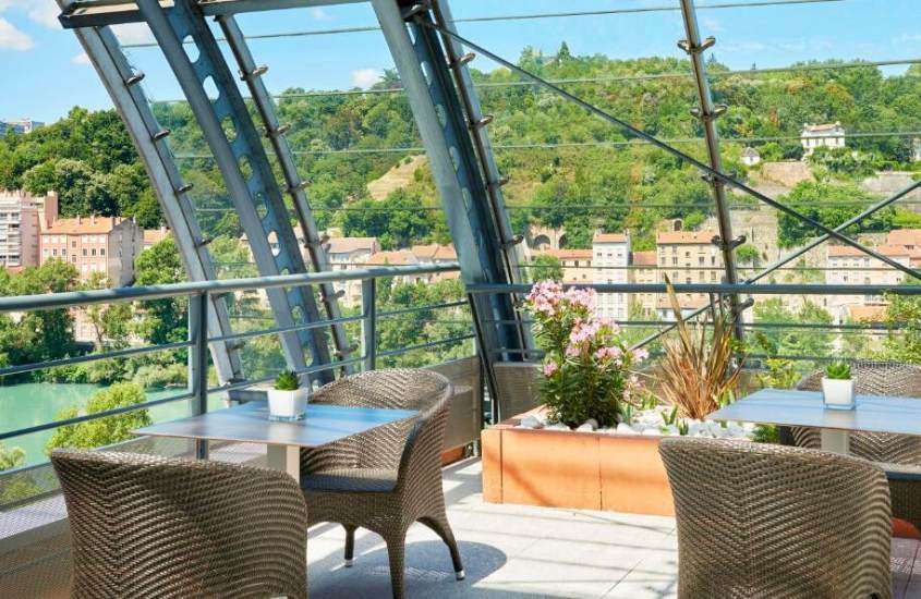 durante o dia, cadeiras e mesas marrons em varanda de hotel em Lyon com vista para as montanhas