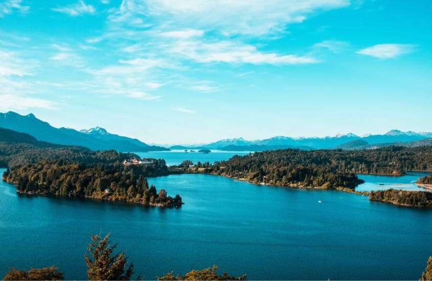 durante o dia, vista aérea de montanhas ao redor de lago em bariloche, uma das principais cidades turísticas da Argentina