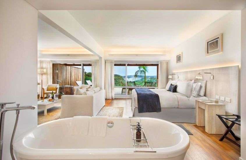 durante o dia, banheira de hidromassagem, cama de casal e sofá em suíte de hotel com vista para as Cataratas do Iguaçu