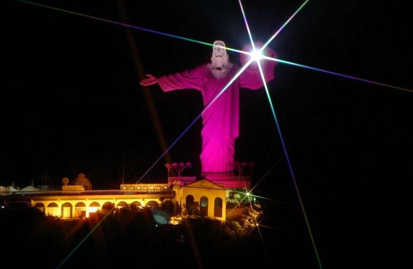 durante a noite, estátua Cristo Luz, iluminada por luz rosa, durante o réveillon em balneário camboriú