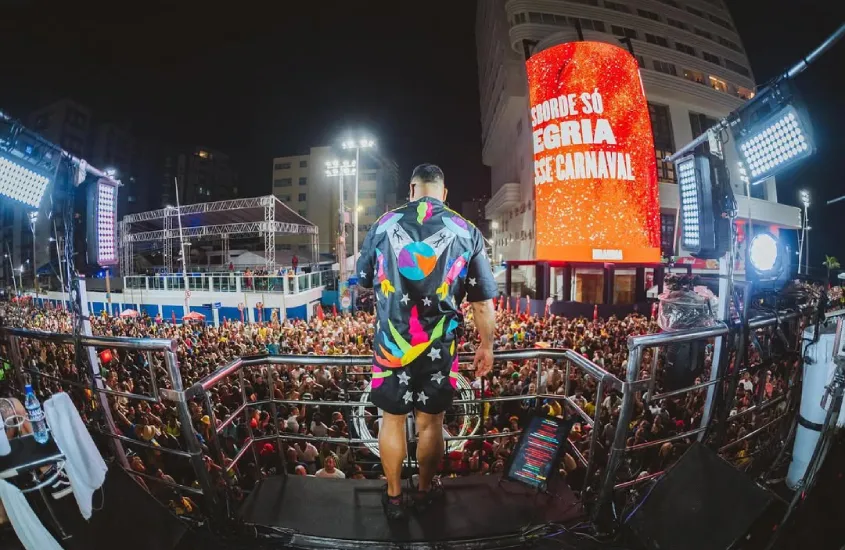 Durante a noite, cantor em cima do trio com público na frente