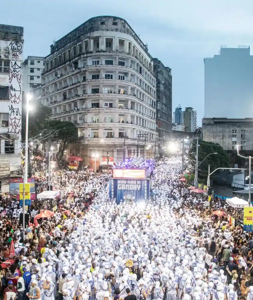 Durante o anoitecer, multidão do bloco Filhos de Gandhy curtindo o carnaval de Salvador