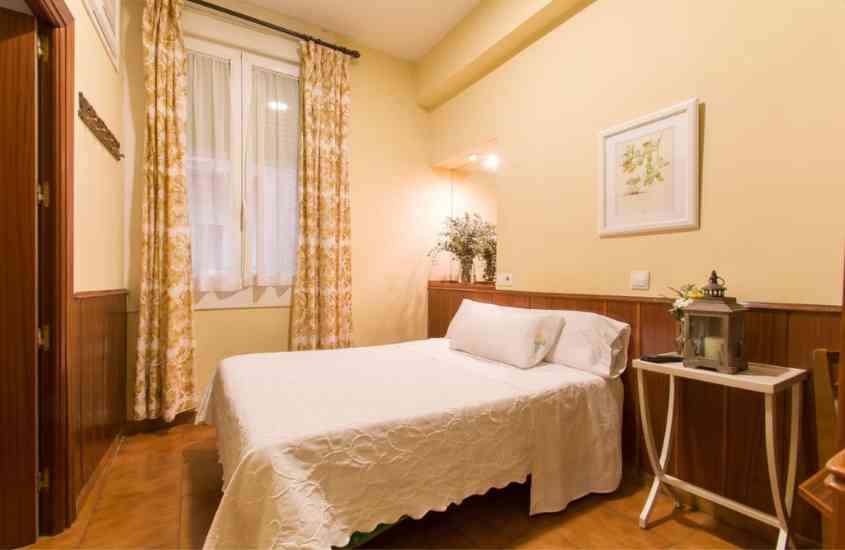 cama de casal forrada com lençol branco, em suíte de hotel em madri com paredes amarelas
