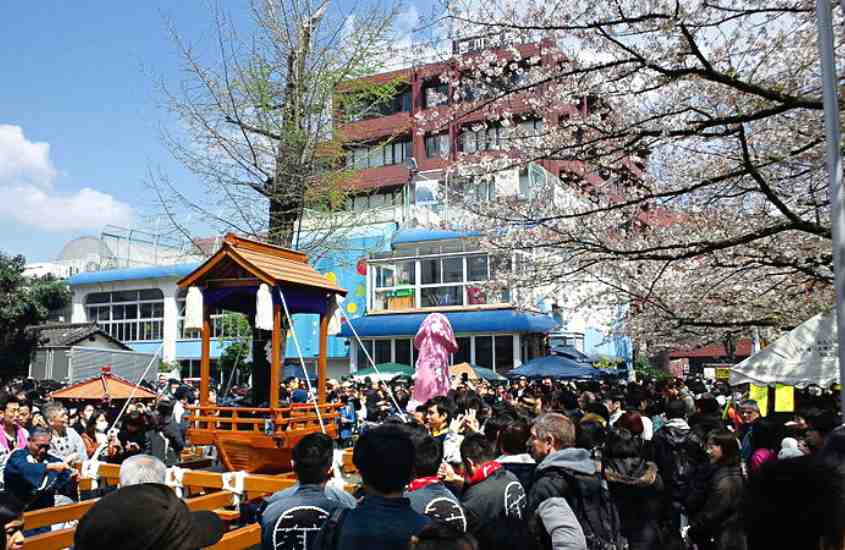 durante o dia, diversas pessoas em desfile de um dos festivais da cultura japonesa
