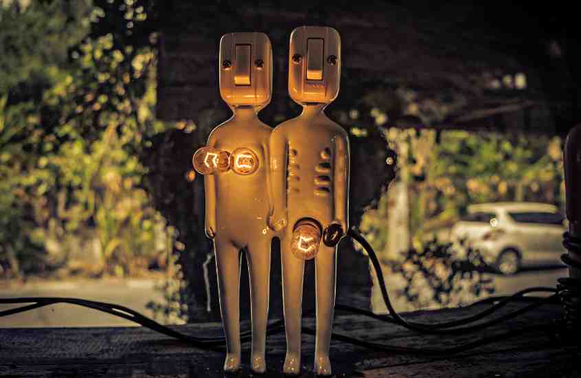 luminárias em formato de homem e mulher nus dando as mãos