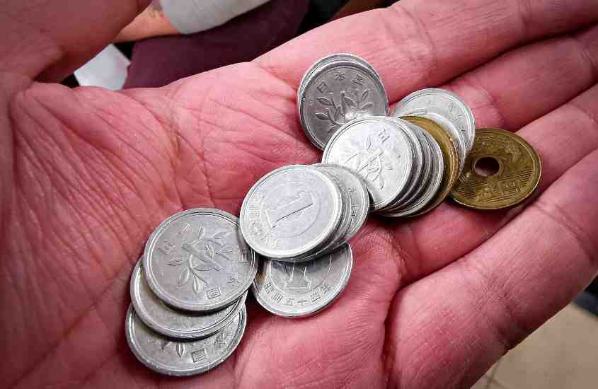 moedas de iene em cima de mão aberta de pessoa branca