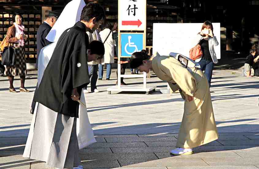 durante o dia, japoneses curvando-se um para o outro, um ato importante na cultura japonesa