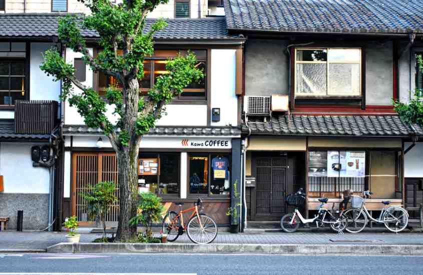 durante o dia, bicicletas estacionadas em frente a casas em rua do japão