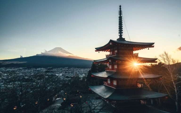 durante pôr do sol, vista aérea de templo tradicional japonês e pico de vulcão coberto de neve