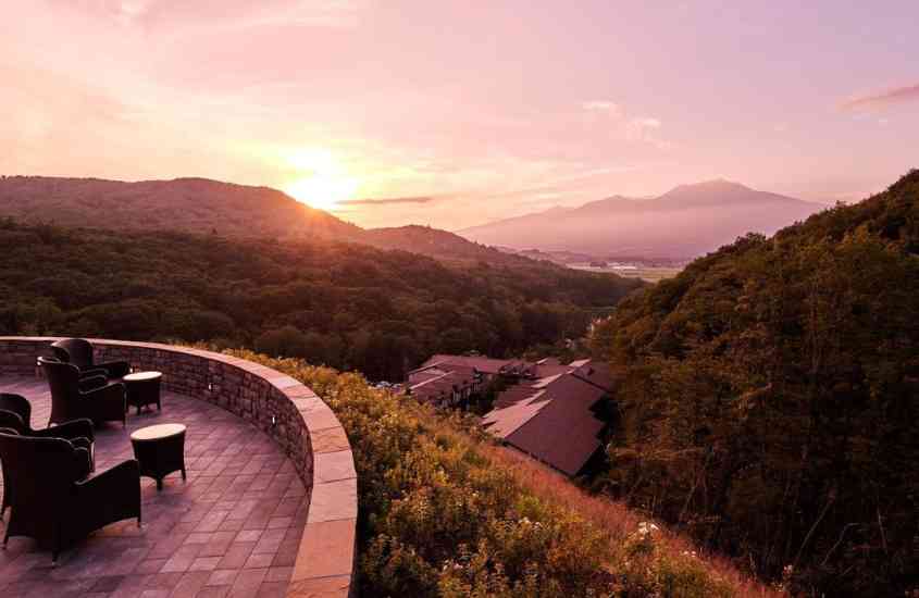 durante entardecer, poltronas em varanda ao ar livre de hotel no japão com vista para as montanhas