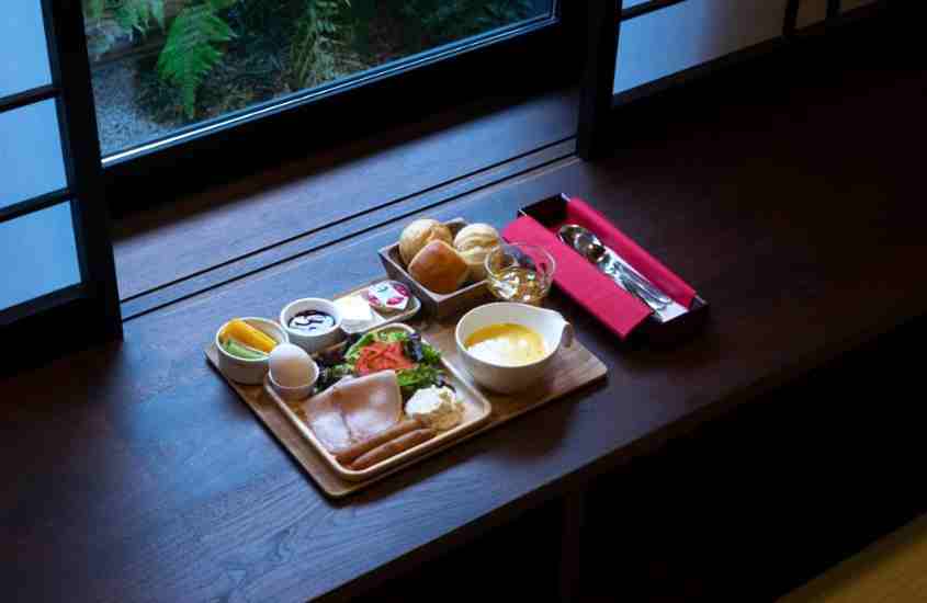 pães, sopa e salada em cima de tábua de madeira, em um dos ryokans em kyoto