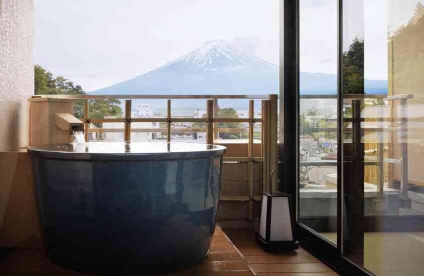 durante o dia, banheira em varanda de hotel no japão com vista para o monte fuji